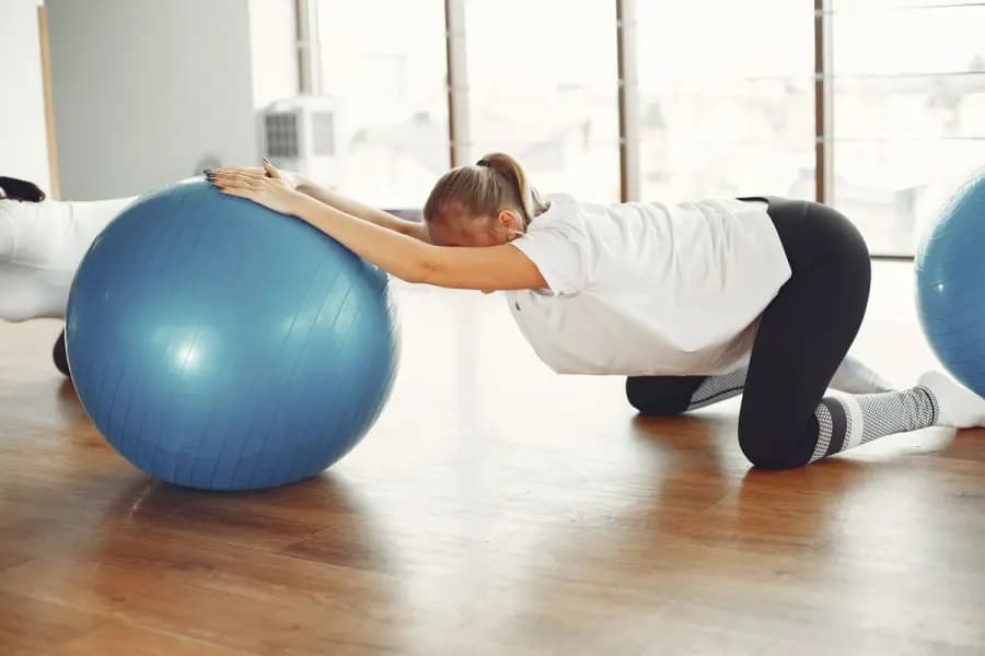 Prenatal & Postnatal Back Pain Physiotherapy Bangalore Prenatal postnatal back pain physiotherapy Bangalore — pregnant patient performing safe stability-ball back-pain exercise from the Mandara pregnancy programme delivered at home by Pro Physiotherapy JP Nagar
